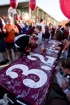 Participants sign their name to a banner for the 3.2 Mile Run in Remembrance.