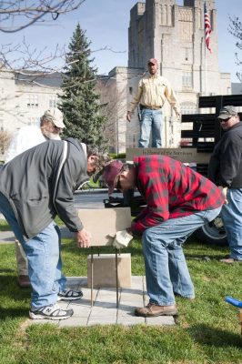 Workers install one of two benches to honor the survivors of April 16, 2007.