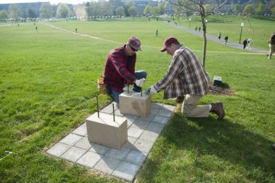 Workers install one of two benches to honor the survivors of April 16, 2007.
