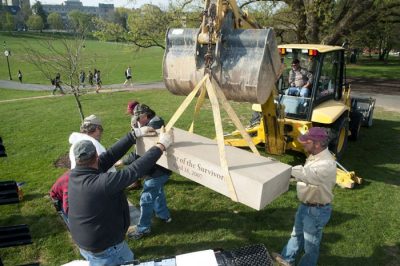 Workers install one of two benches to honor the survivors of April 16, 2007.