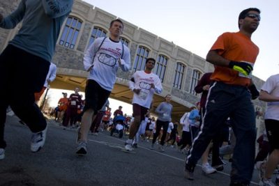 Participants in the 3.2 Mile Run in Remembrance pass beneath Torgersen Hall.