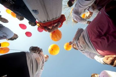 Participants hold balloons before the start of the 3.2 Mile Run in Remembrance.